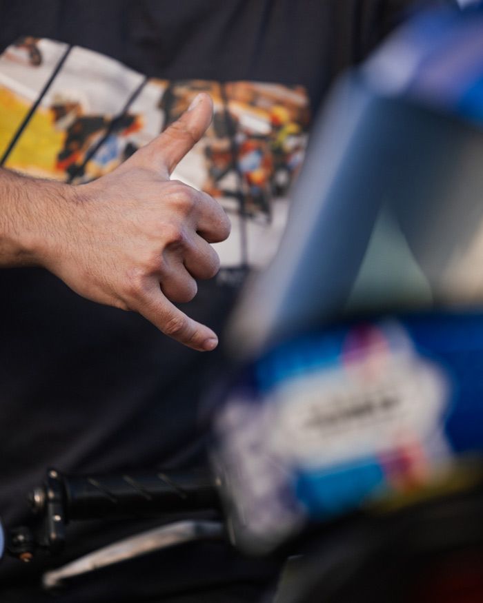 Gen Z - Λεπτομέρεια χεριού του Μιχάλη δίπλα στο κράνος Shoei NXR2, σε χειρονομία αναβάτη – Gas Rider Stories #5